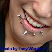 Foto von einem lächelnden Mund mit Piercings.