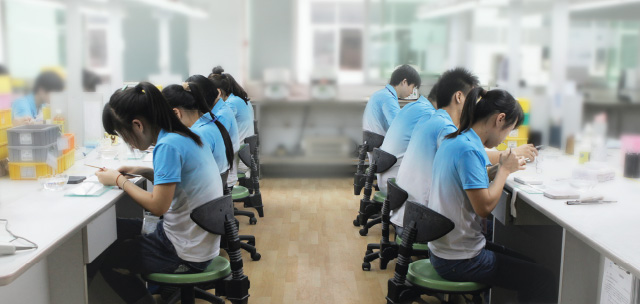 Asiatische Mitarbeiter fertigen Zahnersatz